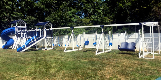 home playground with different types of swings and two towers connected with a bridge home playgrounds